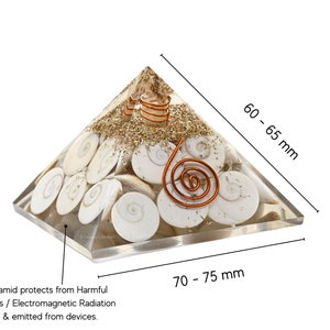Puede incluir: Una pirámide de cristal transparente con una espiral de alambre de cobre y conchas blancas en su interior. La pirámide mide aproximadamente 6,5 cm de alto y 7,5 cm de ancho. La pirámide de orgon protege de las radiaciones EMF nocivas / radiaciones electromagnéticas generadas y emitidas por los dispositivos.