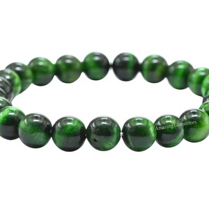 May include: Green tiger's eye gemstone bracelet with round beads. The bracelet is made of natural stones and is approximately 8 inches in length.