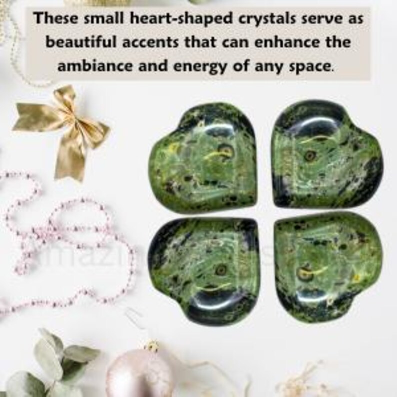 Puede incluir: Cuatro cristales verdes en forma de coraz&oacute;n con vetas negras se muestran sobre una superficie blanca. Un lazo dorado, un collar de perlas y un adorno rosa est&aacute;n en el fondo. El texto dice: "Estos peque&ntilde;os cristales en forma de coraz&oacute;n sirven como hermosos acentos que pueden mejorar el ambiente y la energ&iacute;a de cualquier espacio."