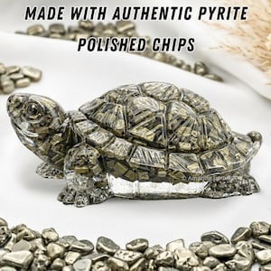 May include: A detailed sculpture of a turtle made from polished pyrite chips. The turtle has a textured shell and is surrounded by loose pyrite chips. The text "MADE WITH AUTHENTIC PYRITE POLISHED CHIPS" is at the top.