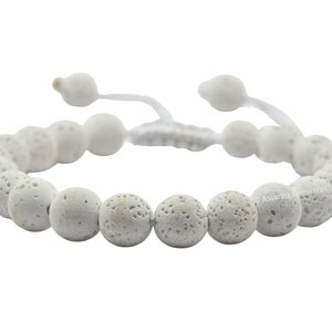 Op de afbeelding: Wit lavastenen armband met een wit koord en een verstelbare knoop sluiting.