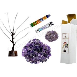 K&ouml;nnte beinhalten: Amethyst-Kristallbaum mit Holzsockel, eine kleine Flasche &auml;therisches &Ouml;l, ein Nagelknipser und eine T&uuml;te Amethyst-Kristalle. Die Kristalle sind lila und der Baum ist aus Draht gefertigt.
