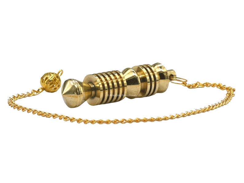 Op de afbeelding: Een gouden slinger met een puntige punt en een ketting. De slinger heeft een reeks ringen rond het midden.