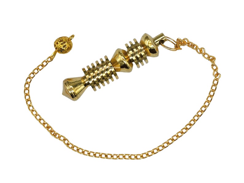 Op de afbeelding: Een gouden metalen slinger met een ketting en een kleine bal aan het uiteinde. De slinger heeft een spiraalvormig ontwerp en wordt gebruikt voor radi&euml;sthesie of waarzeggerij.