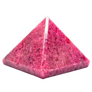 May include: A polished, pyramid-shaped gemstone in a vibrant shade of pink. The pyramid has a square base and a pointed top, with visible natural textures and variations in color. The words "Amazing Gemstones" are printed on the base.