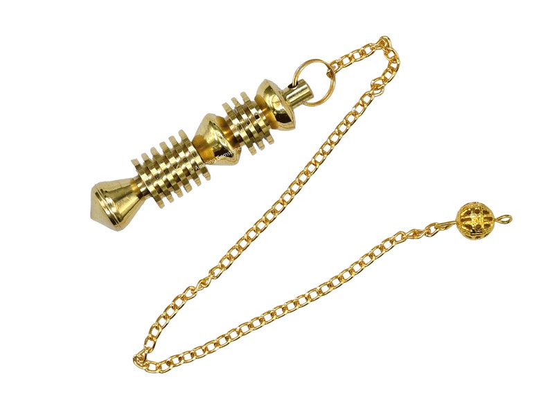 Op de afbeelding: Een gouden metalen slinger met een spiraalvormig ontwerp en een ketting. De ketting heeft een kleine, ronde, gouden metalen bal aan het einde.