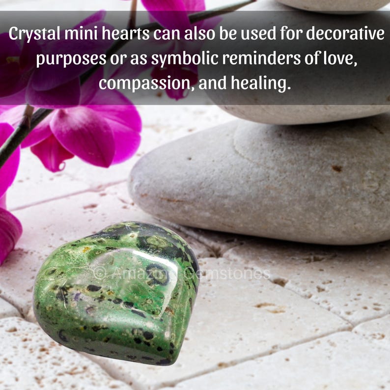 Puede incluir: Un coraz&oacute;n de cristal verde con motas negras, sobre una superficie de baldosas blancas. Junto a &eacute;l, piedras grises lisas y una orqu&iacute;dea rosa. El texto dice: "Los mini corazones de cristal tambi&eacute;n se pueden utilizar con fines decorativos o como recordatorios simb&oacute;licos de amor, compasi&oacute;n y curaci&oacute;n."