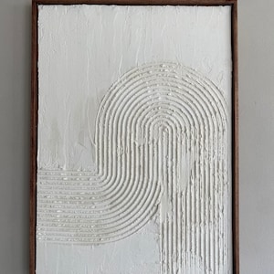 May include: White textured abstract art with a raised design of curved lines in a wooden frame.