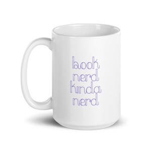 May include: White ceramic mug with a purple outline of the text "book nerd kinda nerd" printed on the front.