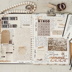 May include: A journal spread with the text "WHERE THERE'S A WILL... THERE'S A WAY" and "BINGO". The pages are decorated with washi tape, tags, and a wooden bead garland. The spread includes handwritten notes, a photo, and the words "new goals" and "2019".