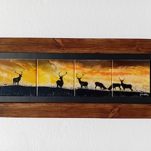Peut inclure: Une œuvre d'art en carreaux encadrée représentant la silhouette de cinq cerfs sur fond de coucher de soleil. Les carreaux sont disposés horizontalement et présentent un dégradé de teintes orange, jaune et rouge.