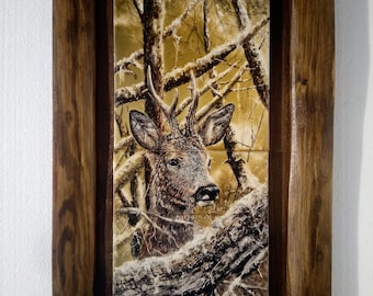 May include: A framed tile artwork featuring a detailed painting of a deer in a snowy forest setting. The deer is brown with white markings and has large antlers. The background is a muted brown and gold with white snow and branches.