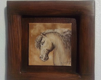 Puede incluir: Una pintura enmarcada de la cabeza de un caballo blanco con un fondo marrón. La pintura está en un marco de madera oscura.