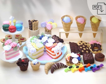 May include: A collection of felt play food items, including cakes, cupcakes, macarons, ice cream cones, cookies, candy, and a croissant. The food items are arranged on a white surface with a wooden stand holding the ice cream cones.