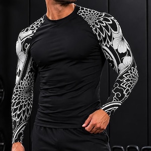 May include: Black long-sleeved athletic top with white floral patterns on the sleeves, worn with black athletic shorts. The background shows gym equipment, including weights and kettlebells, suggesting a fitness theme.