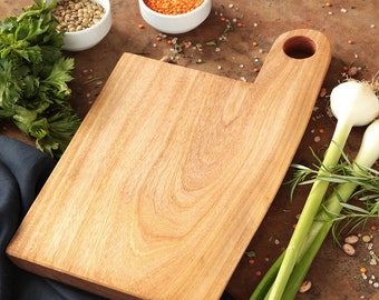 Rustic cutting food board made of walnut wood with hole handle