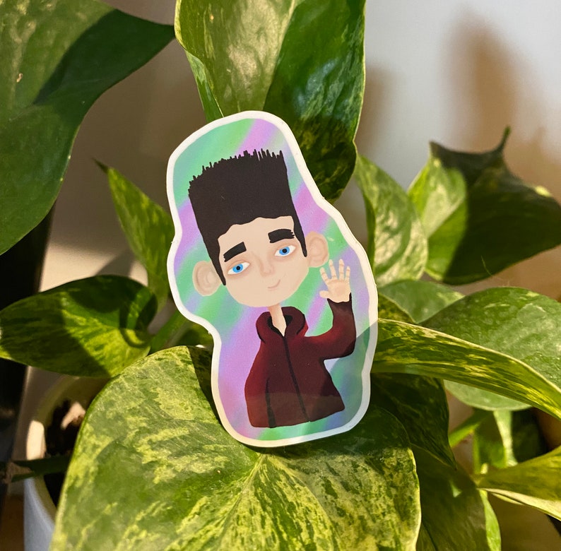 May include: A sticker featuring a cartoon character with black hair, blue eyes, and a red shirt. The character is waving with one hand and has a light blue background with a purple and green swirl pattern.