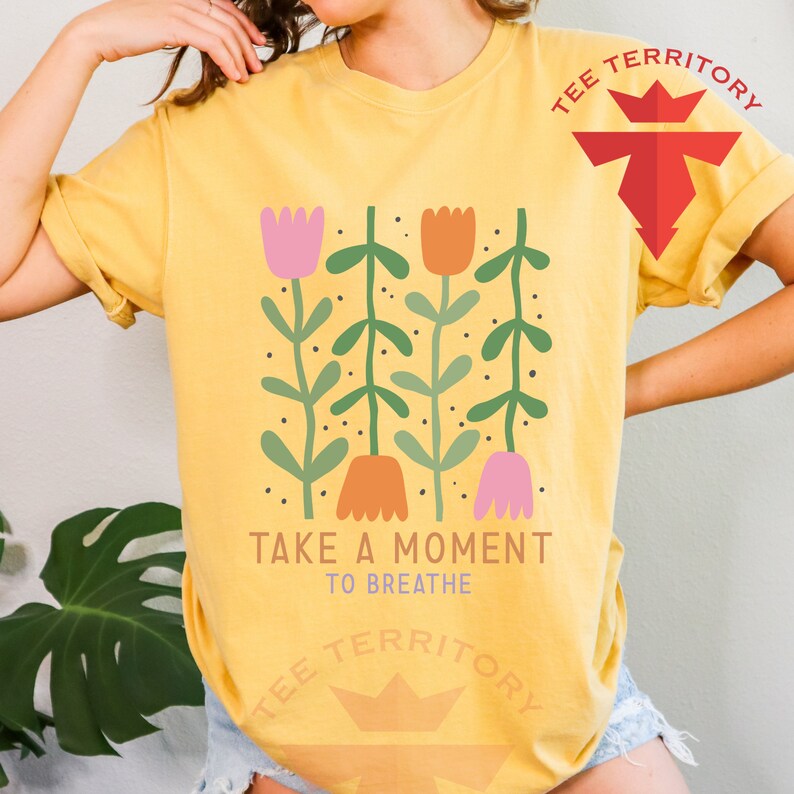 a woman wearing a yellow t - shirt that says take a moment to breathe