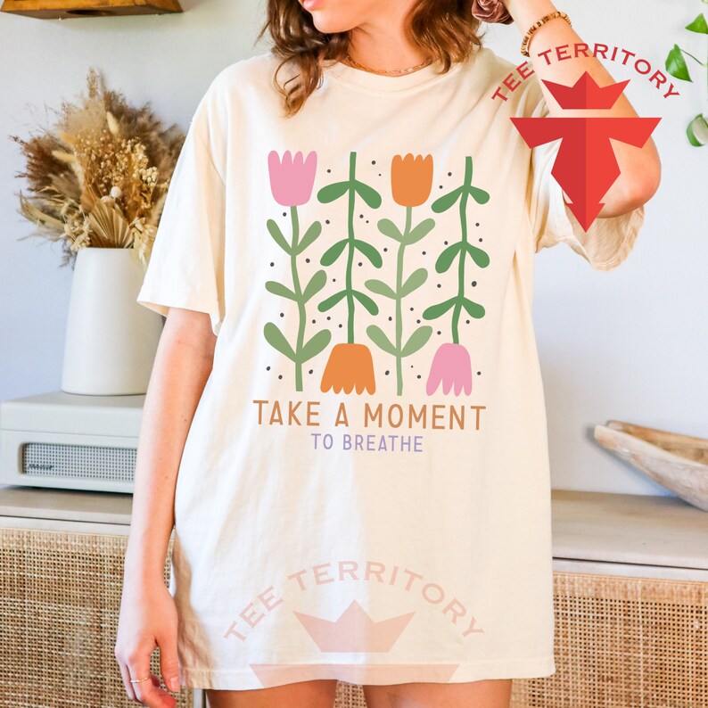 a woman wearing a t - shirt that says take a moment to breathe