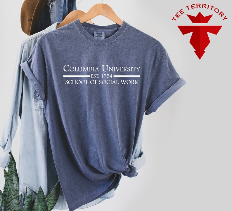 May include: A blue t-shirt with white text that reads "Columbia University Est. 1754 School of Social Work".