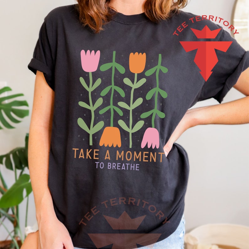 a woman wearing a t - shirt with flowers on it