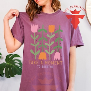 a woman wearing a t - shirt that says take a moment to breathe
