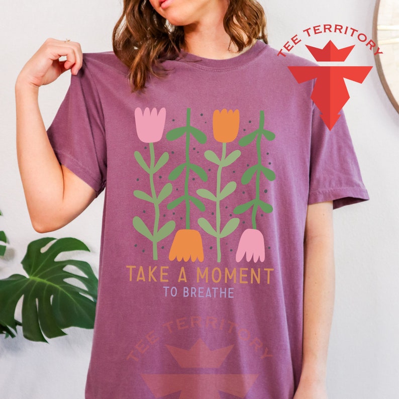 a woman wearing a t - shirt that says take a moment to breathe