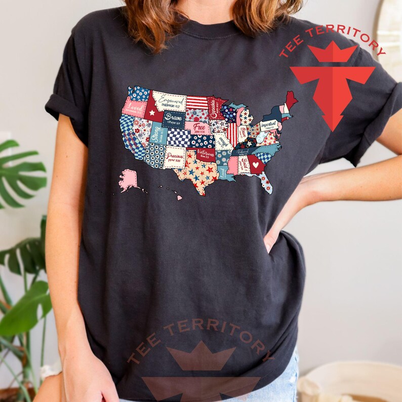 Pu&ograve; includere: Una maglietta nera con un design a patchwork degli Stati Uniti d'America. Ogni stato &egrave; un motivo diverso con parole come "Loved", "Blessed", "Free", "Welcome" e "Dream" su di essi.