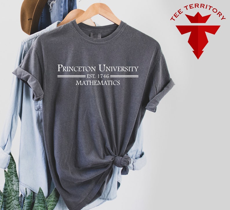 May include: A dark gray t-shirt with white text that reads "Princeton University Est. 1746 Mathematics".