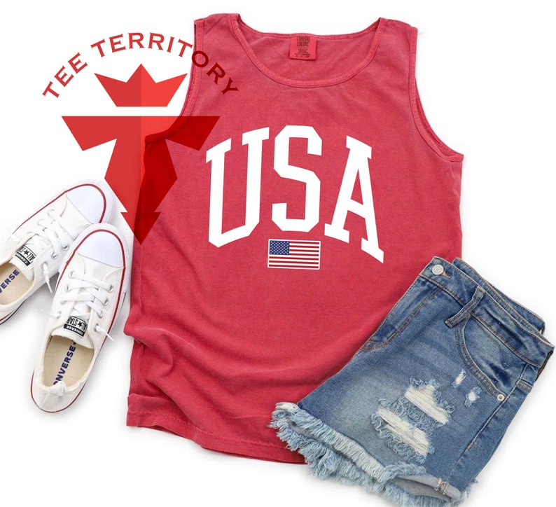 May include: Red sleeveless tank top with a white "USA" graphic and a small American flag. The tank top is made of a soft, comfortable material.