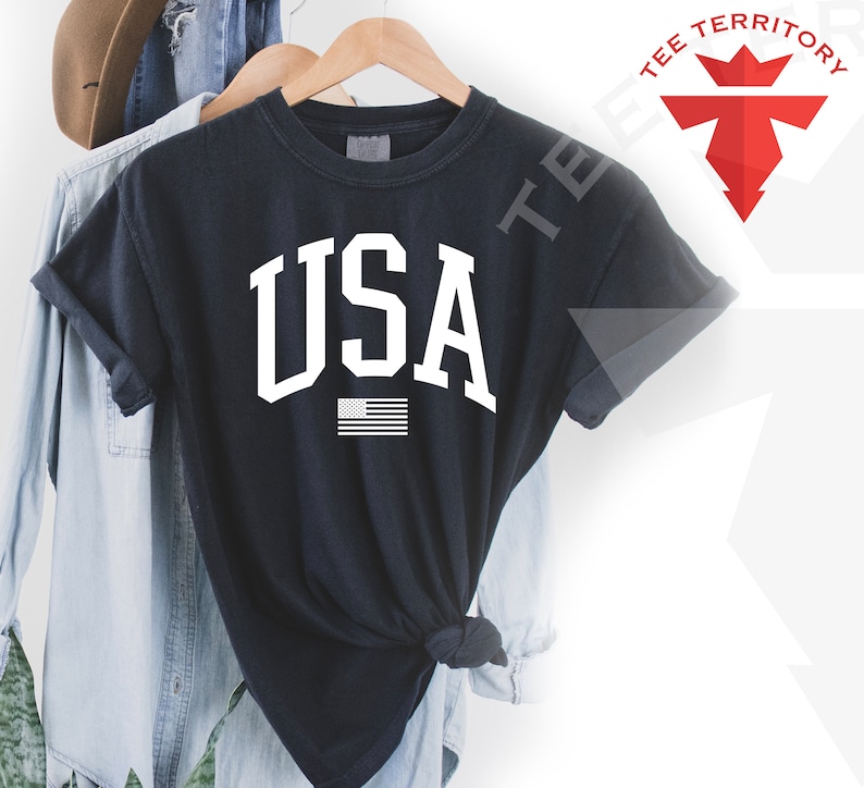 May include: Black t-shirt with a white "USA" graphic and a small American flag.