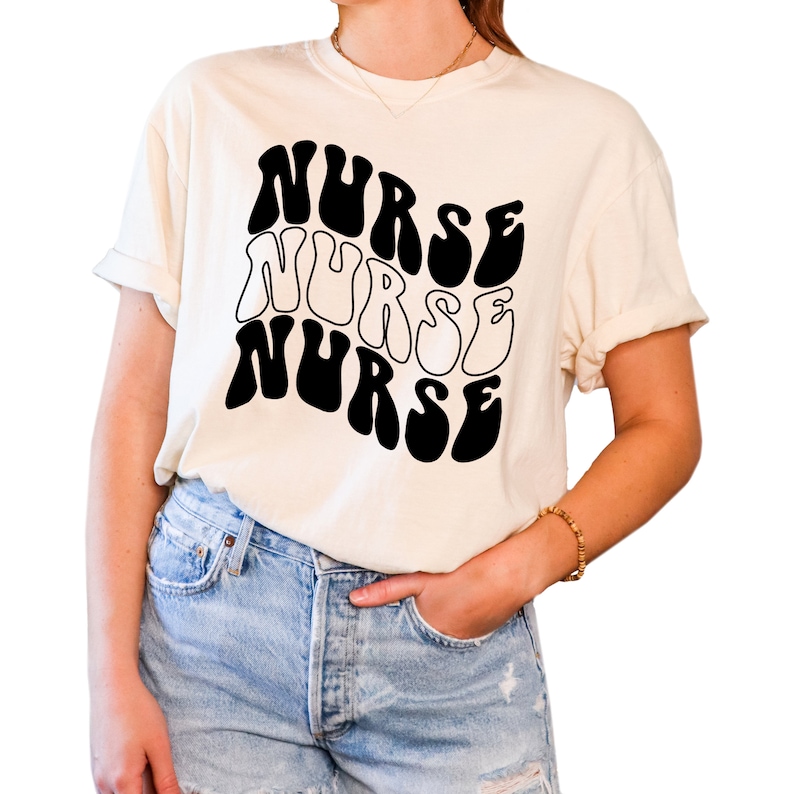 Puede incluir: Una camiseta blanca con un gr&aacute;fico negro de la palabra "NURSE" repetida tres veces en una fuente retro y ondulada.