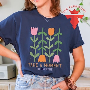 a woman wearing a t - shirt that says take a moment to breathe