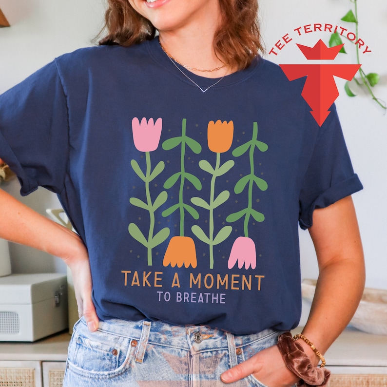 a woman wearing a t - shirt that says take a moment to breathe