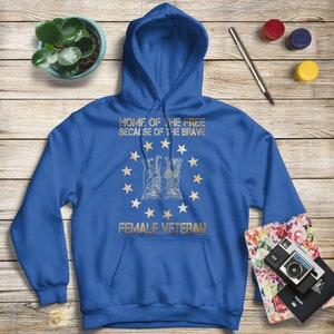 Puede incluir: Sudadera con capucha azul real con un estampado dorado de un par de botas militares, un c&iacute;rculo de estrellas y el texto "Home of the Free Because of the Brave Female Veteran".