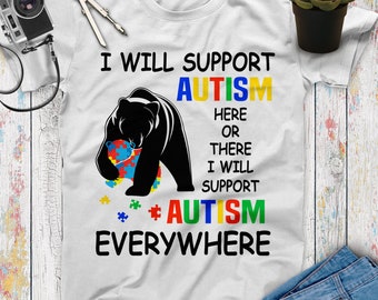 May include: White t-shirt with a black bear holding a puzzle piece. The text on the shirt reads "I will support autism here or there I will support autism everywhere".