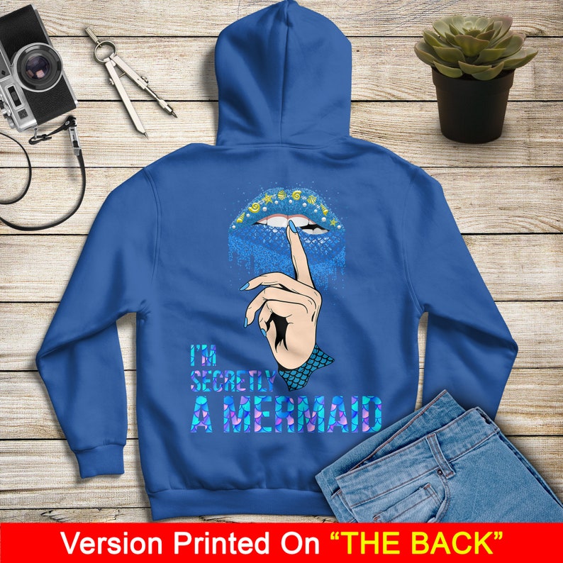 Peut inclure: Sweat-shirt &agrave; capuche bleu avec un motif de l&egrave;vres en paillettes bleues et le texte "I'm Secretly A Mermaid" imprim&eacute; au dos.