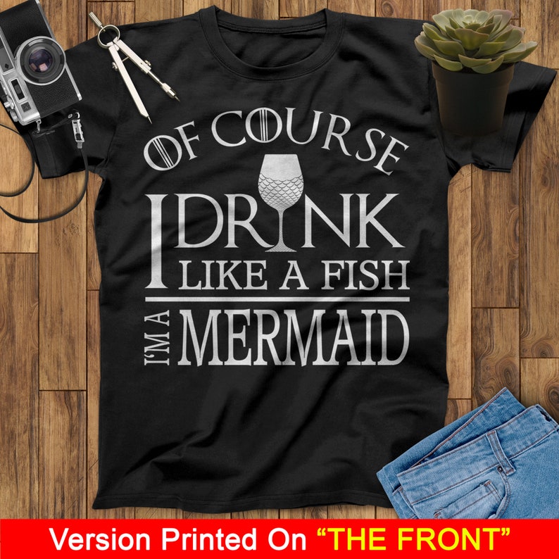 May include: Black t-shirt with white text that reads "Of course I drink like a fish I'm a mermaid" and a white wine glass with a mermaid tail design.