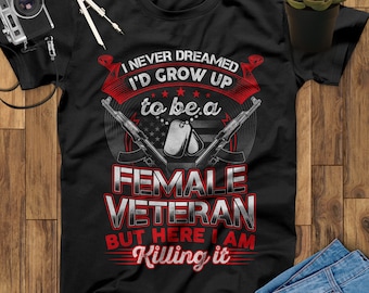 May include: Black t-shirt with the text "I NEVER DREAMED I'D GROW UP to be a FEMALE VETERAN BUT HERE I AM Killing it." The design includes crossed rifles, dog tags, and the American flag.
