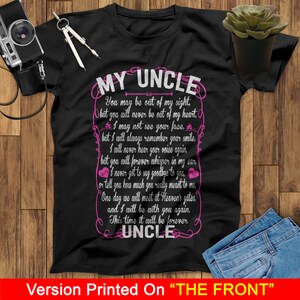 May include: Black t-shirt with a pink graphic design that says "My Uncle" and includes a poem about remembering a loved one. The poem reads: "You may be out of my sight, but you will never be out of my heart. I may not see your face, but I will always remember your smile. I will never hear your voice again, but you will forever whisper in my ear. I never got to say goodbye to you, or tell you how much you really meant to me. One day we will meet at Heaven's gates, and I will be with you again. This time it will be forever. Uncle."
