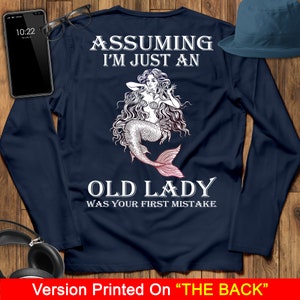 May include: Navy blue long-sleeve shirt with a mermaid graphic and the text "Assuming I'm just an old lady was your first mistake".