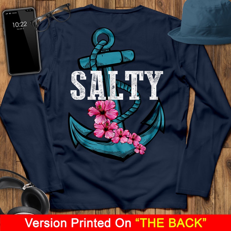 May include: Navy blue long-sleeve shirt with a white anchor and the word "SALTY" printed on the back. Pink hibiscus flowers are around the anchor.