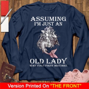 May include: Navy blue long-sleeve shirt with a mermaid graphic and the text "Assuming I'm just an old lady was your first mistake".