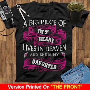 May include: Black t-shirt with a pink graphic that reads "A big piece of my heart lives in heaven and she is my daughter".