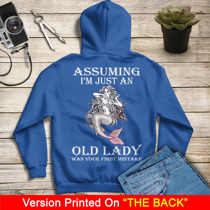 May include: A royal blue hoodie with a mermaid illustration and the text "Assuming I'm just an old lady was your first mistake" printed on the back.