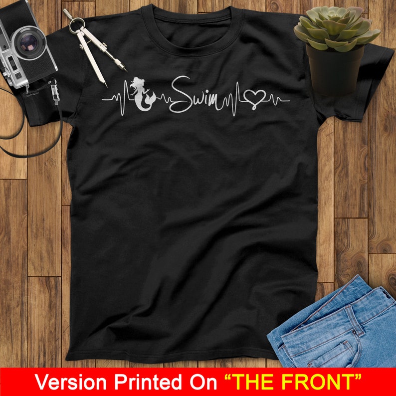 Puede incluir: Camiseta negra con un gr&aacute;fico blanco de una sirena con una l&iacute;nea de latido del coraz&oacute;n y la palabra "Swim" en cursiva.