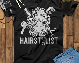 May include: Black t-shirt with a white graphic of a woman with long hair, scissors, a hair dryer, and a comb. The text "HAIRSTYLIST" is printed below the graphic.