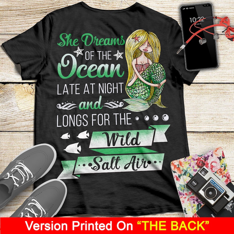 May include: Black t-shirt with a mermaid illustration and the text "She Dreams of the Ocean Late at Night and Longs for the Wild Salt Air".
