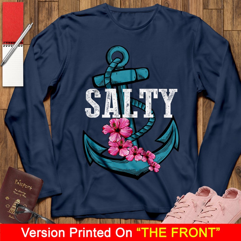 May include: A navy blue long-sleeved t-shirt with a blue anchor and pink flowers. The text "SALTY" is printed in white above the anchor.