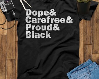 May include: Black t-shirt with white text that reads "Dope & Carefree & Proud & Black".